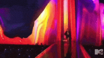 a man is standing in front of a stage with a mtv logo on it