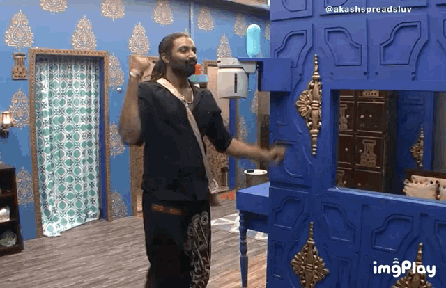 a man with a beard is dancing in a room with blue walls and a watermark that says imgplay