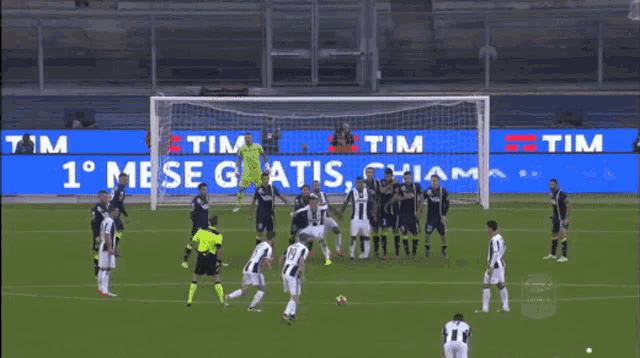a soccer game is being played in front of a large tim sign