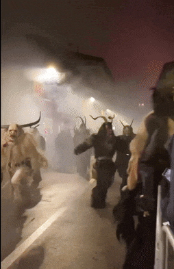 a group of people walking down a street at night