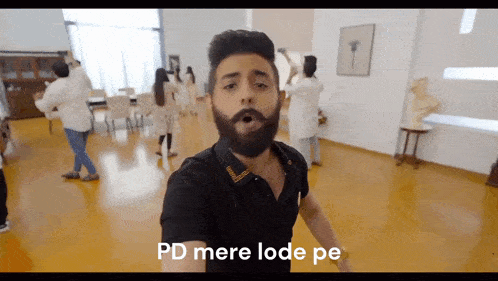 a man with a beard is standing in a room with the words pd mere lode pe written on the bottom
