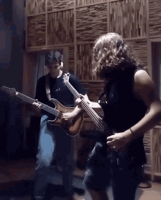 a man with curly hair is playing a guitar