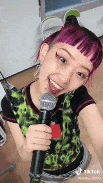 a woman with purple hair holds a shure microphone