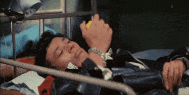 a man in a black leather jacket is laying in a bed