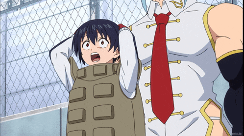 a man with a red tie is standing next to a girl with a bullet proof vest on