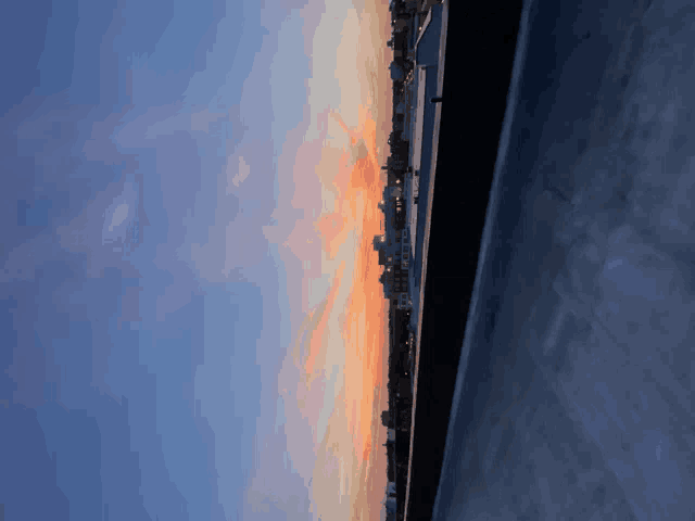 a sunset over a city with a few buildings in the distance