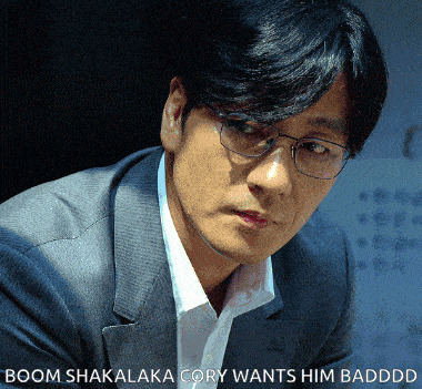 a man wearing glasses and a suit with the words boom shakalaka cory wants him badddd