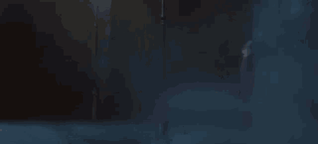 a person is standing in a dark room with smoke coming out of a doorway .