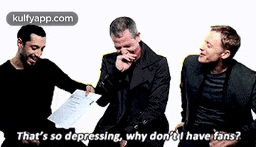 three men are sitting next to each other and laughing .