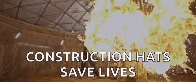 a sign that says construction hats save lives with a large explosion in the background
