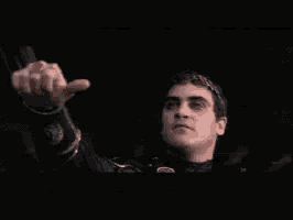 a man in a black jacket is giving a thumbs up sign