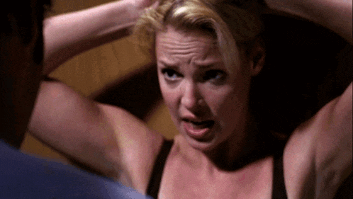a woman in a black bra has her hands in her hair while looking at a man