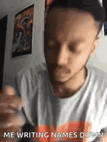 a man with a beard is holding a pen and writing names down .