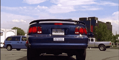 a blue car with a bumper sticker that says " was is not the answer " is parked in a parking lot