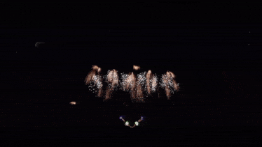 fireworks are displayed in the night sky with a white circle in the center