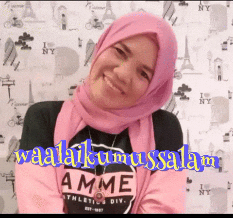 a woman wearing a pink hijab and a black shirt that says amme