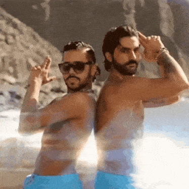 two men are standing next to each other on a beach