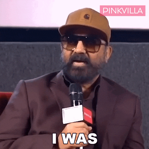 a man wearing a hat and sunglasses holds a microphone and says " i was "