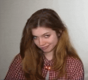 a woman with long hair is wearing a plaid shirt and a necklace