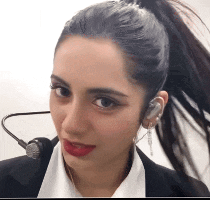 a woman wearing a ponytail and a microphone around her neck