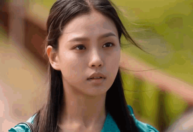 a woman with long hair is looking at the camera