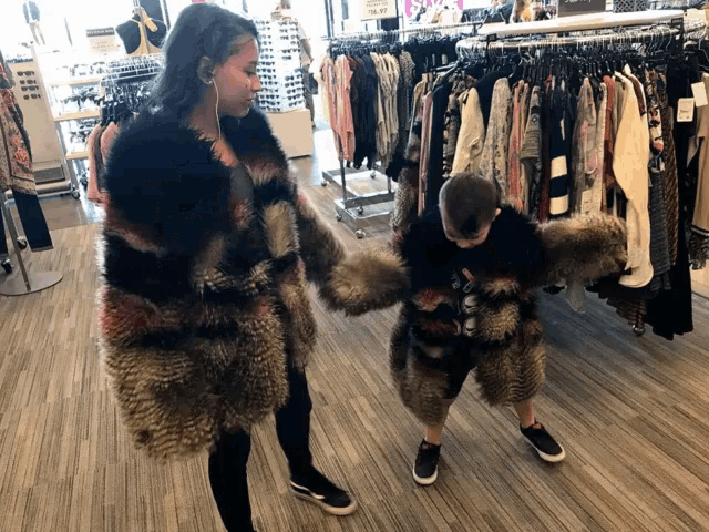 a woman and a boy are holding hands in a store
