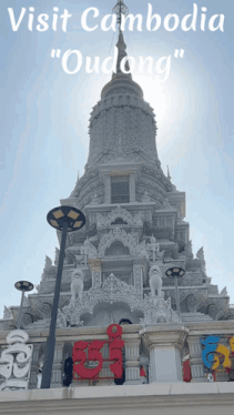 a very tall building with the words visit cambodia " oudong " written on it