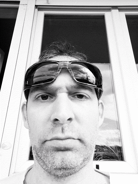a man wearing sunglasses looks at the camera