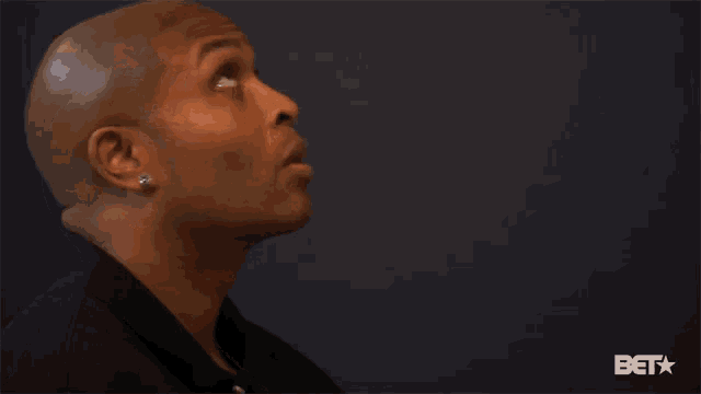 a man is looking up with a bet logo in the corner