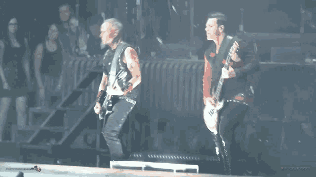 two men playing guitars on a stage with the word rock on the bottom