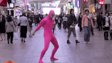 a person in a pink bodysuit is walking down a street