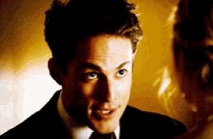 a man in a suit and tie is looking at a woman in a dress