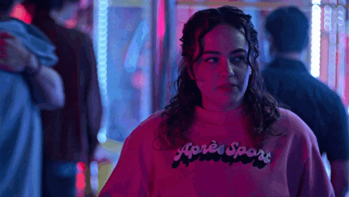 a woman wearing a pink sweatshirt with the word après sport on it