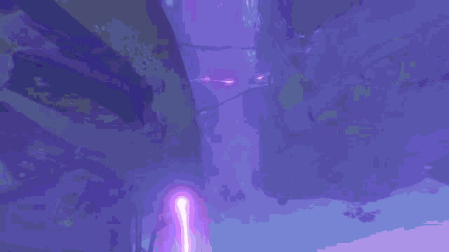 a purple lightning bolt is coming down from the sky in a dark room .