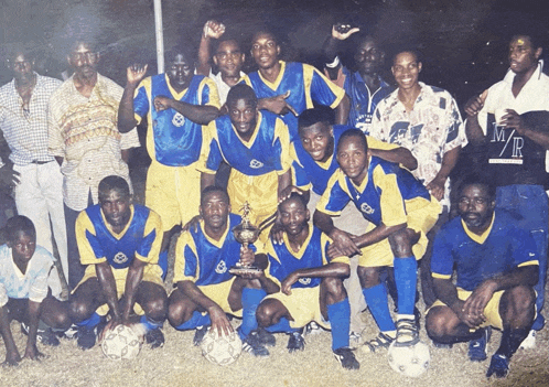 a group of soccer players posing for a photo with a man wearing a shirt that says m/r