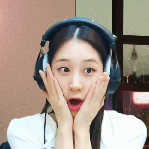 a young woman wearing headphones is making a surprised face .