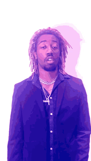 a man with dreadlocks wearing a purple suit and a necklace with the letter y on it