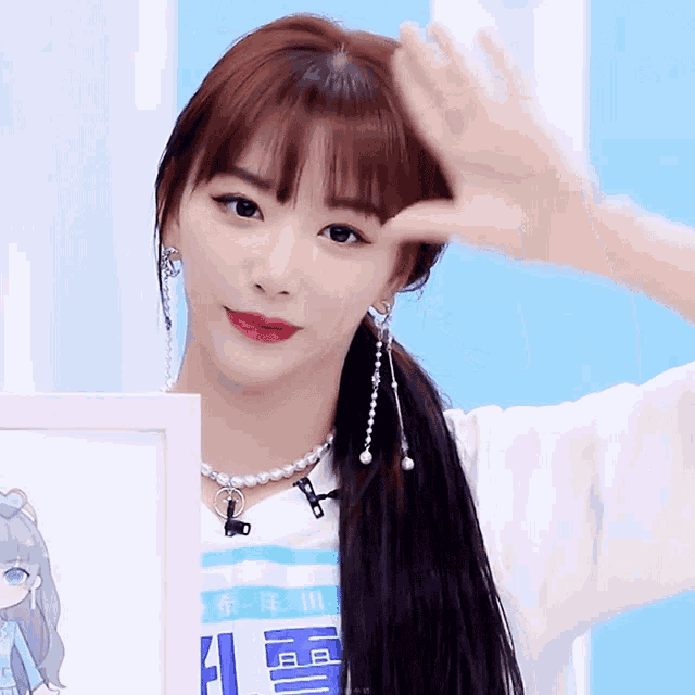 a girl wearing a pearl necklace and earrings is holding a picture frame with chinese characters on it
