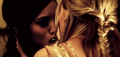 two women are kissing and one has black lipstick on