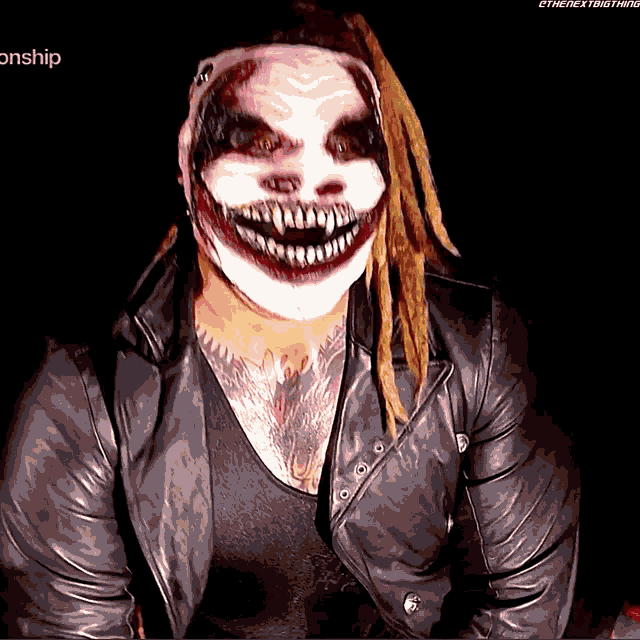 a man with dreadlocks is wearing a mask and a leather jacket with the words " the next thing " on the bottom