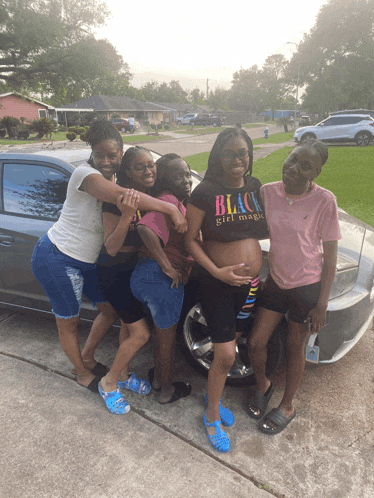 a group of girls are posing for a picture with a pregnant woman wearing a black girl magic shirt