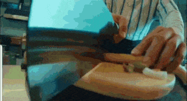 a close up of a person cutting a piece of wood