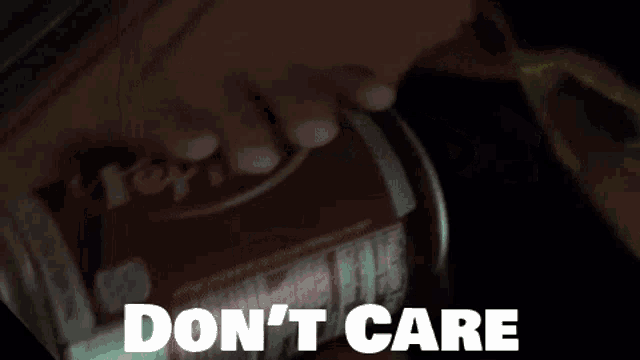 a person is holding a can of soda in their hand with the words do n't care written on the bottom .