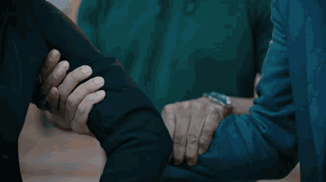 a man in a green shirt holds a woman 's hand