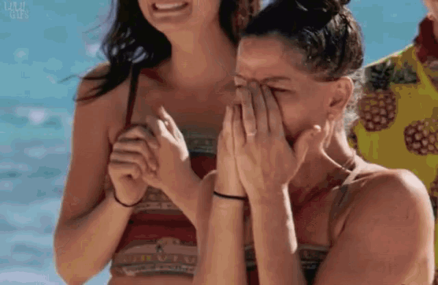 a woman covering her face with her hands while laughing