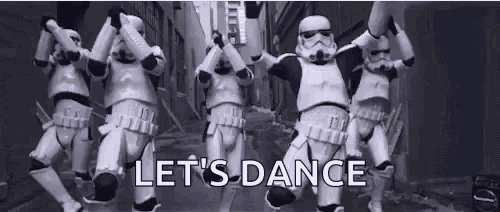a group of stormtroopers are dancing on a street in a video .