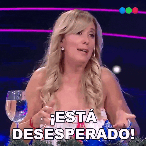 a woman is sitting at a table with a glass of water and the words " esta desesperado " written on her face