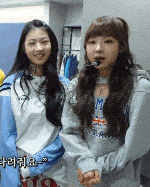 two girls are standing next to each other and one has a sweatshirt that says england on it
