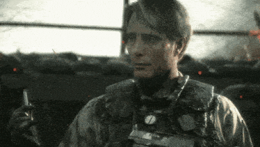 a man in a military uniform holds a lighter and a gun