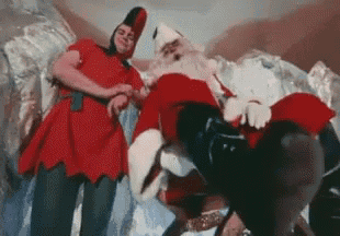 a man in a red dress is standing next to a man in a santa suit